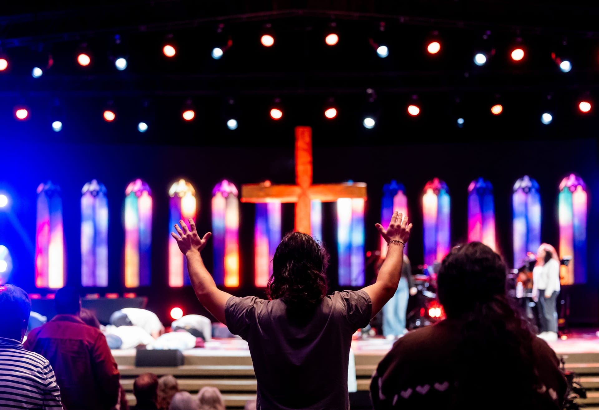 Jongeren met opgeheven handen tijdens een worshipavond